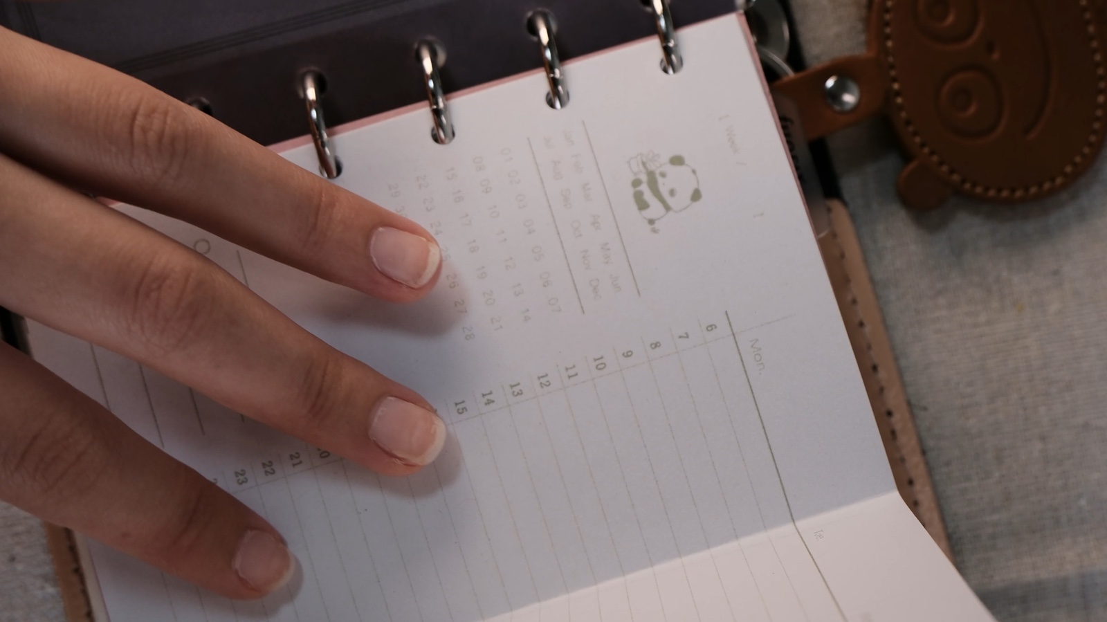Printed ATAKURI planner pages being added to a ring notebook